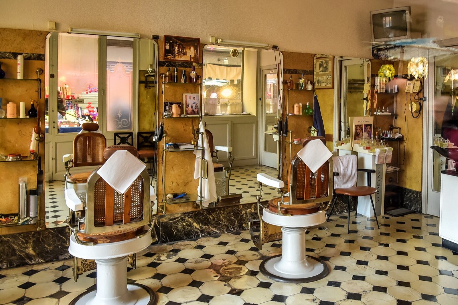 Interior de una barbería clásica de Manresa con sillones y suelo de baldosas