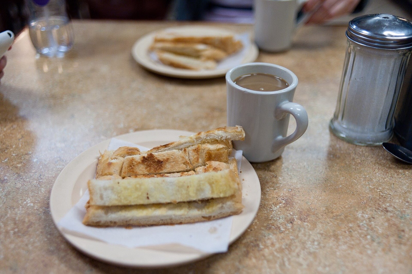 Café con leche y tostadas en la mesa de una cafetería